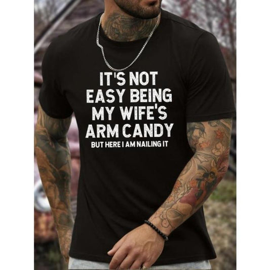 It Is Not Easy Being My Wife's Arm Candy Print, Men's Round Crew Neck Short Sleeve, Simple Style Tee Fashion Regular Fit T-Shirt, Casual Comfy Top For Spring Summer Holiday Leisure Vacation Men's Clothing As Gift Made in USA