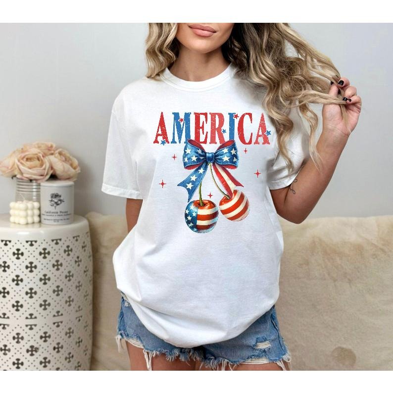 Patriotic and Adorable T - Shirt: Show Your American Spirit with a "AMERICA" Design featuring a Bow and Cherry Graphics
